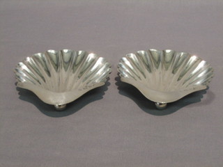 A pair of silver scallop shaped butter dishes, raised on 3 bun feet Birmingham 1919 4 ozs