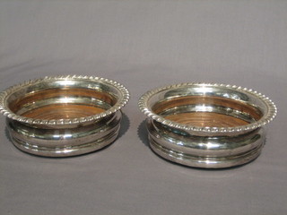 A pair of circular silver plated wine coasters with gadrooned borders 6"