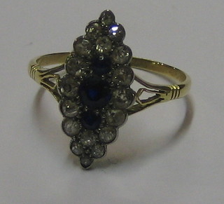 A lady's gold marquise shaped dress ring set 3 sapphires surrounded by numerous diamonds