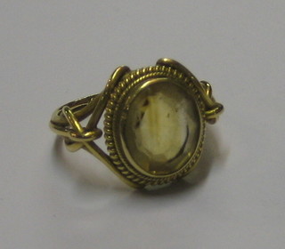 A gold dress ring set an oval brown stone