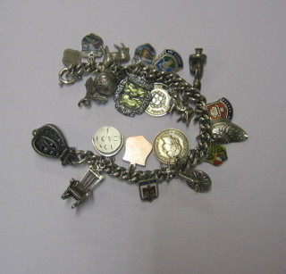 A silver curb link charm bracelet hung 19 various charms 