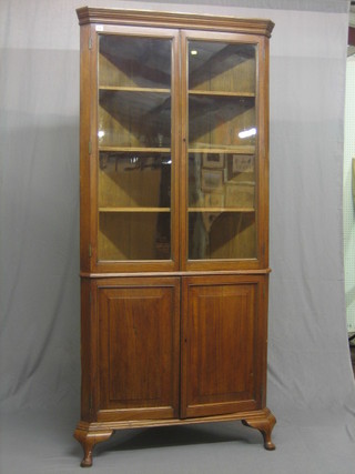 A 19th Century mahogany double corner cabinet, the upper section with moulded cornice, the interior fitted shelves enclosed by panelled doors, the base enclosed by a panelled door and raised on cabriole supports 37"