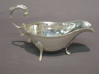 A Georgian style silver plated sauce boat with C scroll handle, raised on 3 hoof feet