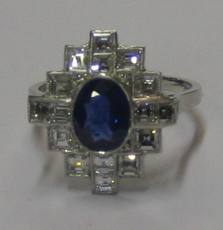 An Art Deco style 18ct white gold dress ring set an oval cut sapphire surrounded by 16 diamonds (approx 1.10/1.50ct)