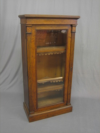 A Victorian oak bookcase, fitted shelves enclosed by glazed panelled doors, flanked by a pair of fluted columns 25"