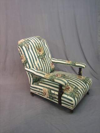 A Victorian oak framed open arm library chair upholstered in green and white striped material