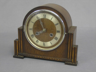 A 1930's chiming mantel clock with silvered dial contained in an oak arch shaped case