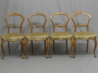 A set of 4 Victorian carved walnut spoon back dining chairs with carved mid rails and upholstered seats