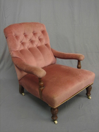 A Victorian oak framed open arm chair upholstered in pink buttoned material