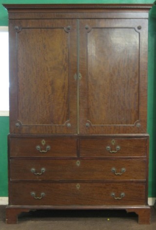 A 19th Century mahogany linen press, the upper section with moulded and dentil cornice, the interior fitted 5 trays enclosed by panelled doors, the base fitted 2 short and 2 long drawers, raised on bracket feet 55"