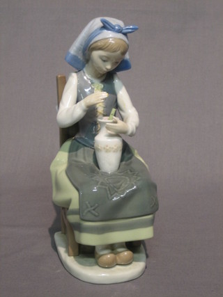 A Lladro figure of a seated girl with vase of flowers (f), base marked EMS 8"