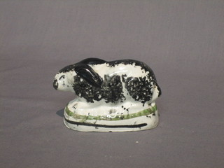 An 18th/19th Century Staffordshire figure of a seated black and white rabbit 3 1/2" (base chipped and holed)