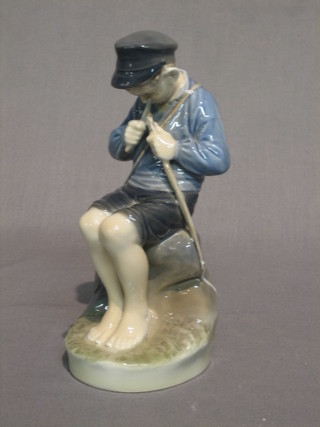 A Royal Copenhagen porcelain figure of a boy fisherman, the base marked 95