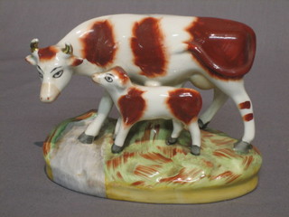 A 19th Century Staffordshire figure of a brown and white cow with calf 3 1/2"