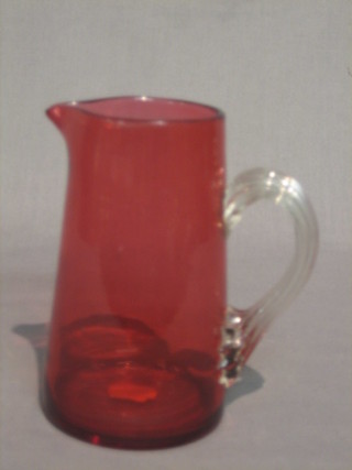 A Victorian cranberry glass jug with clear glass handle 6 1/2"