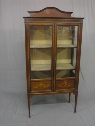 An Edwardian inlaid mahogany display cabinet, the interior fitted shelves enclosed by glazed panelled doors, raised on square tapering supports 33"