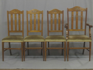 A set of 4 Art Nouveau oak stick and rail back dining chairs, the crested rails inlaid a crown in pewter, raised on square supports (1 carver, 3 standard)