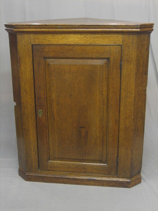 An 18th/19th Century oak corner cabinet enclosed by a panelled door and raised on a platform base 48" (cut at back and side for pipe)