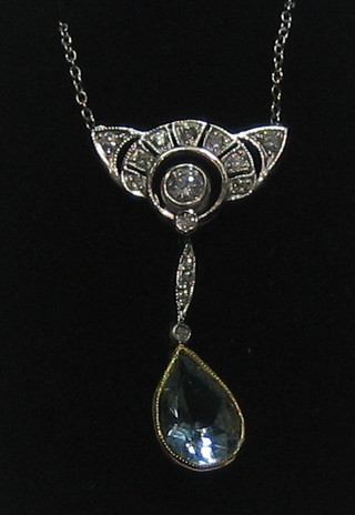 A lady's attractive white gold pendant set a tear drop cut aquamarine supported by diamonds