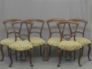 A set of 6 Victorian mahogany balloon back dining chairs with plain mid rails, the upholstered seats of serpentine outline, raised on French cabriole supports