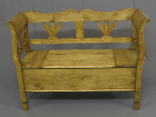 A pine settle with pierced back, the seat with hinged lid 48"