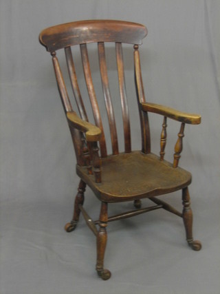 A 19th Century elm stick and rail back kitchen chair on turned supports ending in castors