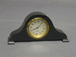 An Art Deco bedroom timepiece with silvered dial and Arabic numerals contained in an Admiral's hat shaped case 7"