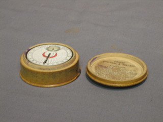 A 19th Century pocket barometer with paper dial and compass 2" contained in  a wooden case