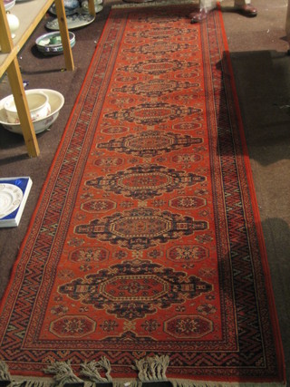 A Persian style  Belgian cotton runner with rust coloured ground and octagons to the centre 135" x 35 1/2"