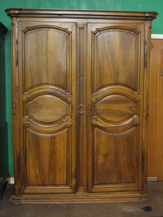 An 18th Century French fruit wood armoire with moulded cornice enclosed by panelled doors, 63" (some old worm holes)