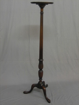 A 20th Century Georgian style fluted mahogany torchere on pillar and tripod supports