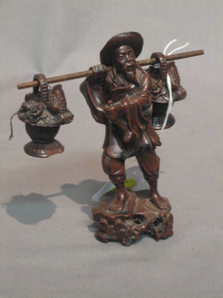 An Eastern carved figure of gentleman with basket of fish and produce 6"