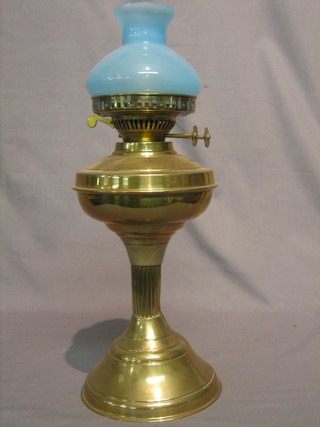 A brass oil lamp with light blue glass shade 17"