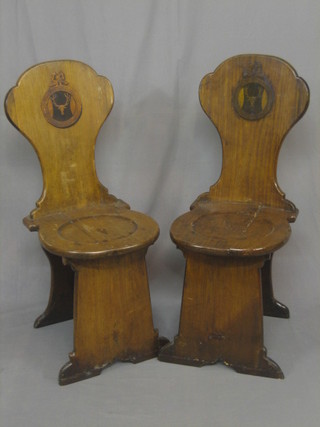 A pair of 17th Century style elm? solid seat hall chairs the backs with armorial decoration