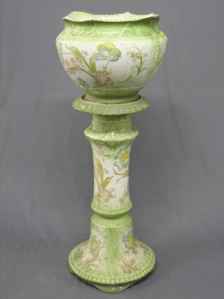 A green and white jardiniere with floral decoration, raised on a stand (base chipped)