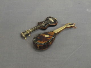 A tortoiseshell model of a mandolin 5" and a do. guitar 4"