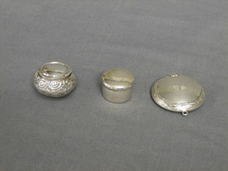 A circular silver rouge pot with engine turned decoration, Birmingham 1942, 2 1/2", an Edwardian embossed silver pill box with hinged lid Birmingham 1900 1", together with a small silver pill/rouge pot Birmingham 1898
