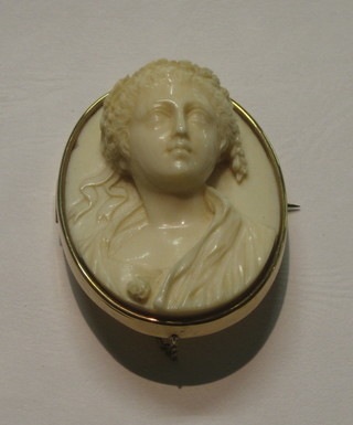 A lady's handsome Victorian oval carved ivory brooch in the form of a head and shoulders portrait of a lady, contained in a gilt mount