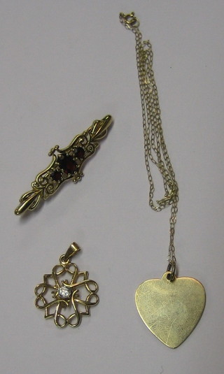 A  9ct gold bar brooch, a 9ct gold heart shaped pendant hung on a gold chain and a gilt metal pendant