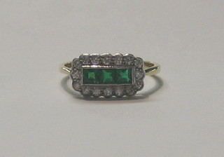 A lady's 18ct yellow gold ring set 3 square cut emerald to the centre surrounded by numerous diamonds