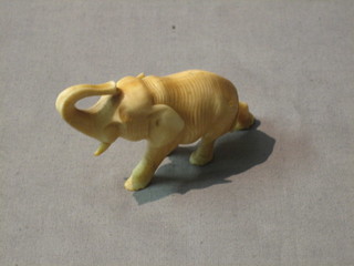 A carved ivory figure of a walking elephant 3" (foot and tusk f)