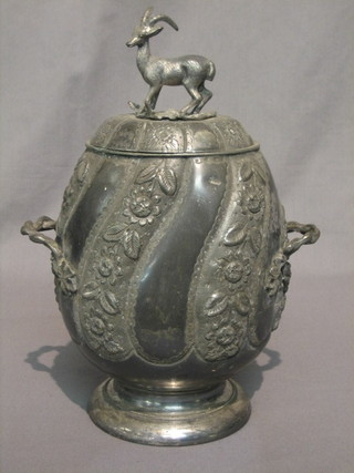 A Victorian embossed Britannia metal oval twin handled  biscuit barrel and cover, raised on a circular spreading foot, the finial  in the form of a stag 11"