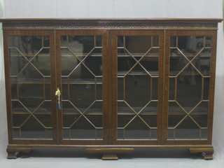 A 19th Century Chippendale style bookcase with blind fret  work frieze,  the  interior  fitted  shelves  enclosed  by  astragal  glazed doors raised on ogee bracket feet 72"
