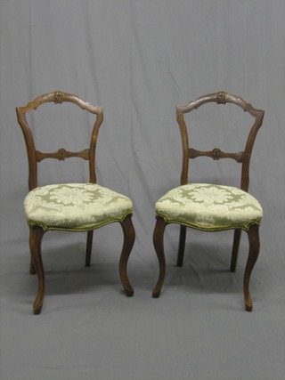 A   pair  of  carved Edwardian walnut spoon  back  dining  chairs with  mid rails and seats of serpentine outline, raised on  cabriole  supports