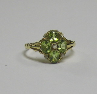 A lady's 18ct gold dress ring set 4 oval cut peridots supported  by diamonds