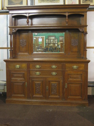 A  honey oak chiffonier sideboard, the raised back with  moulded cornice   incorporating  a  pot  board  above  a  mirrored   panel, supported  by  a  pair of fluted columns with  Ionic  capitals,  the base  fitted 2 long and 2 short drawers above triple cupboards  by M Walker & Sons of Bunhill Row EC, 71"