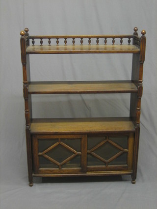An oak Aesthetic movement bookcase with bobbin turned  gallery to the top, fitted 2 shelves above a double cupboard 20"
