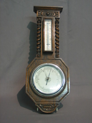 An  aneroid  barometer  and  thermometer  contained  in  an  oak wheel case with spiral turned decoration