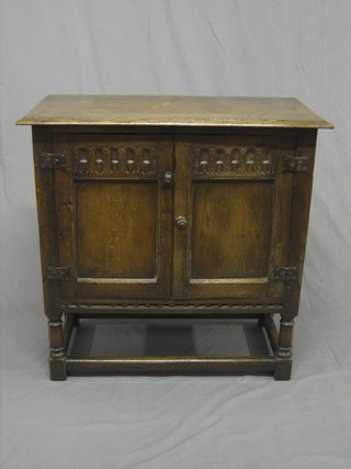 A  reproduction  17th  Century  style  oak  hutch  cupboard  with arcaded decoration, enclosed by a panelled door, raised on turned and block supports 30"