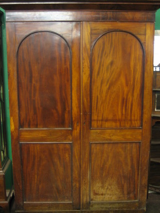 A William IV Channel Islands mahogany wardrobe with moulded cornice enclosed by arch shaped panelled doors 51"